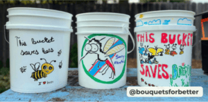 three white mosquito buckets with children's paintings of wildlife