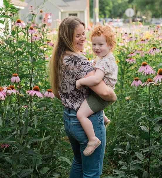 Hannah Monroe_Indianapolis,IN_sm Hannah Monroe holding her daughter in a yard full of native plants including echinacea